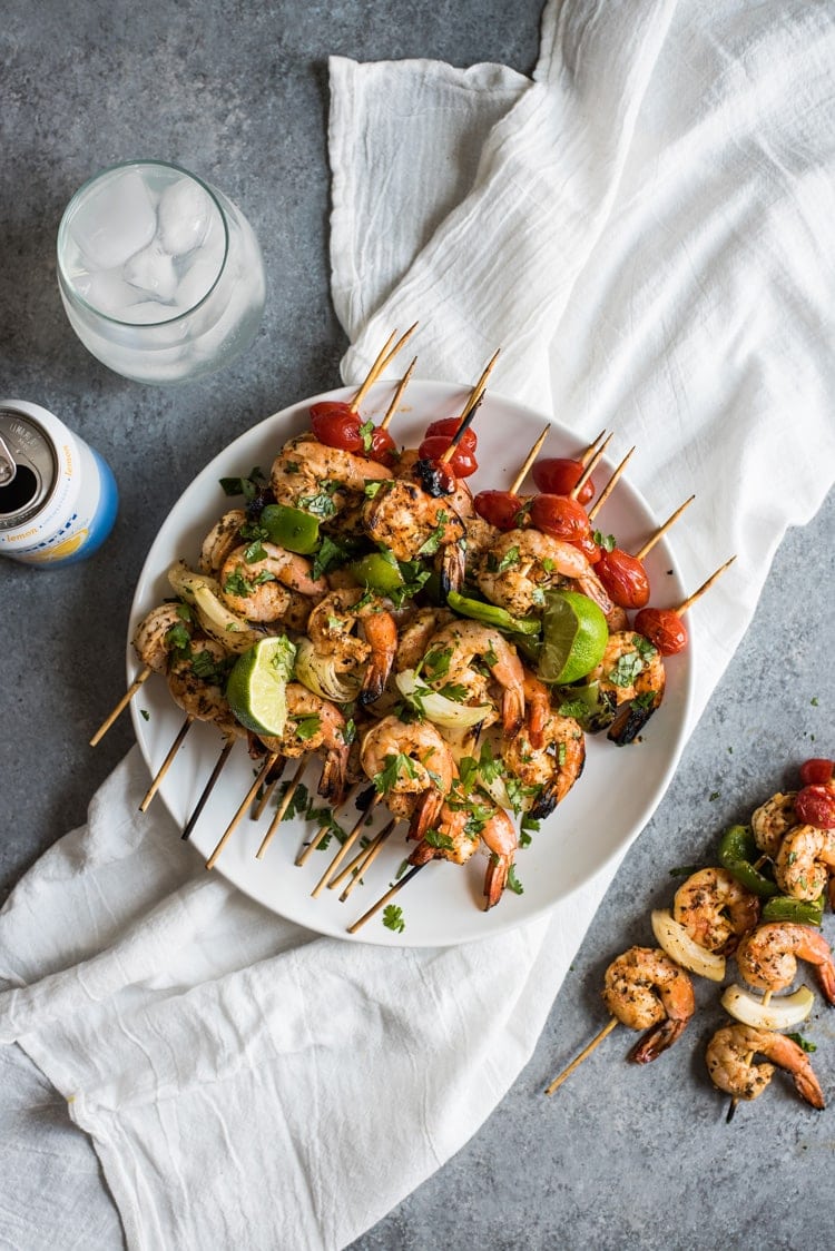 Grilled shrimp skewers on a white plate.