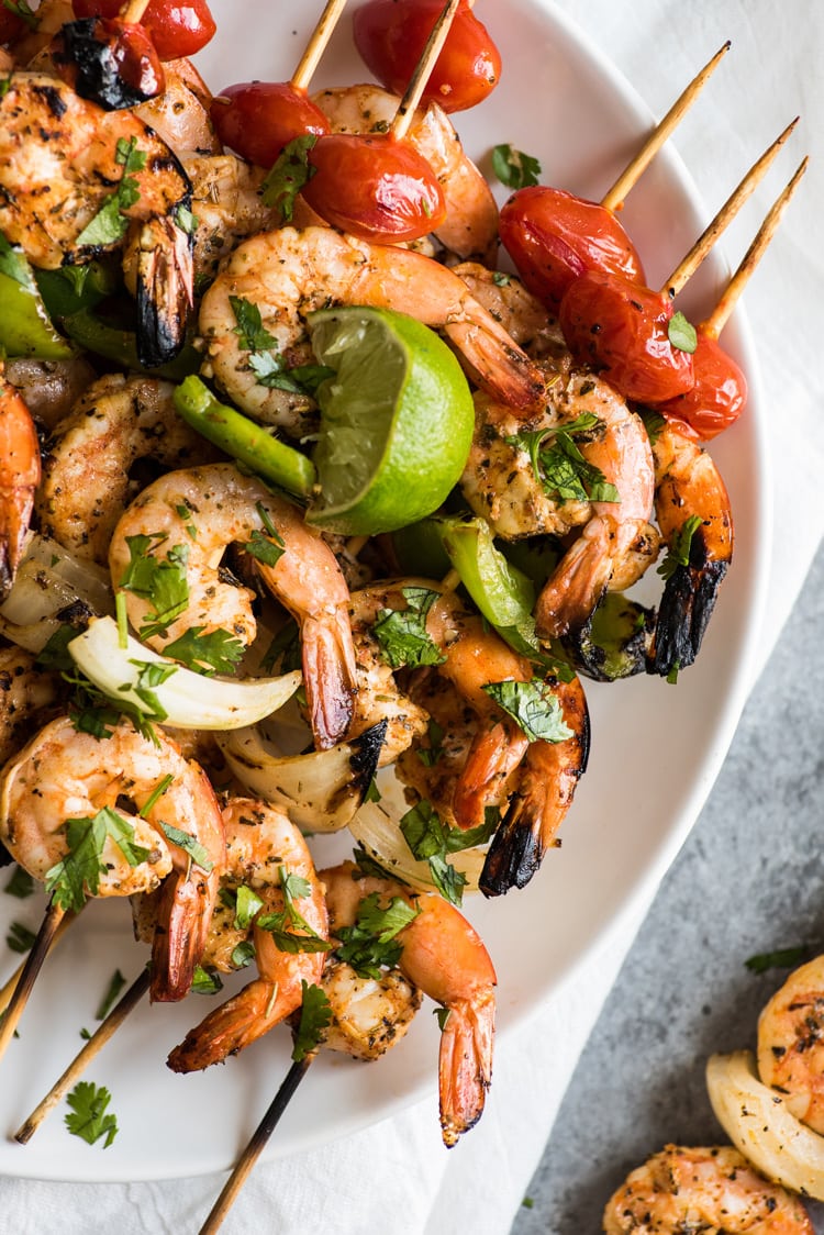 Grilled shrimp skewers topped with lime juice and cilantro.