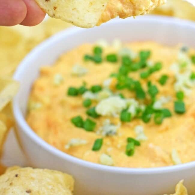 On the party menu is this dangerously good Slow Cooker Buffalo Chicken Dip recipe topped with bleu cheese crumbles and freshly chopped chives. I promise everyone will be asking you for the recipe by the end of the night! - fromcatstocooking.com