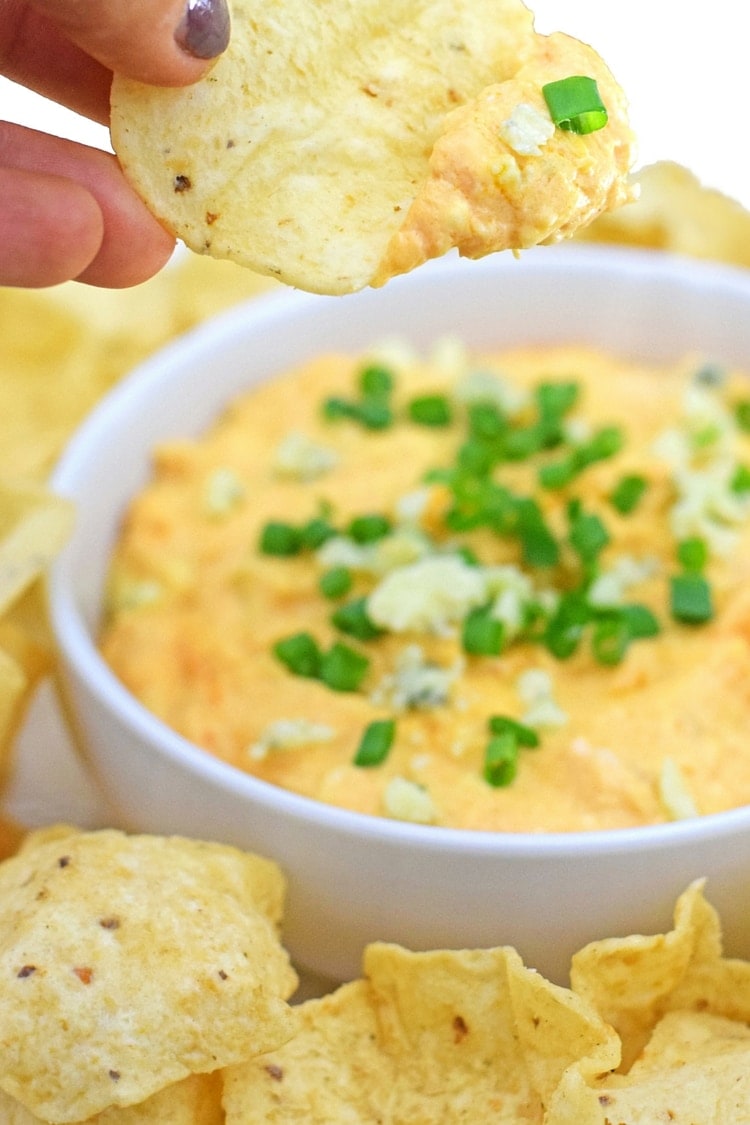 On the party menu is this dangerously good Slow Cooker Buffalo Chicken Dip recipe topped with bleu cheese crumbles and freshly chopped chives. I promise everyone will be asking you for the recipe by the end of the night! - fromcatstocooking.com