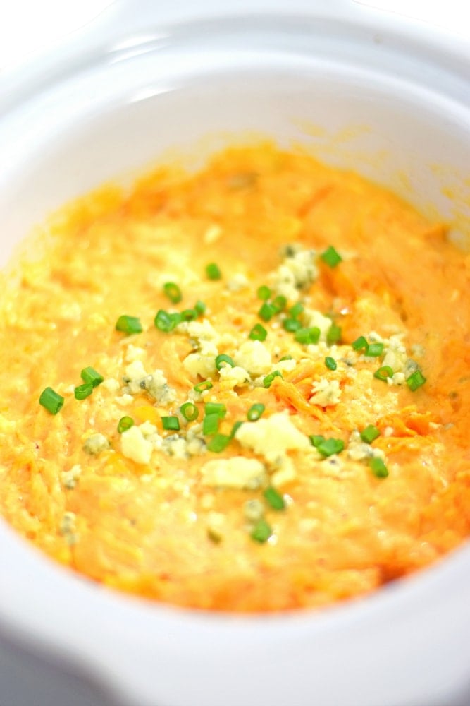 On the party menu is this dangerously good Slow Cooker Buffalo Chicken Dip recipe topped with bleu cheese crumbles and freshly chopped chives. I promise everyone will be asking you for the recipe by the end of the night! - isabeleats.com