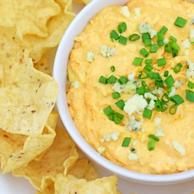On the party menu is this dangerously good Slow Cooker Buffalo Chicken Dip recipe topped with bleu cheese crumbles and freshly chopped chives. I promise everyone will be asking you for the recipe by the end of the night! - fromcatstocooking.com