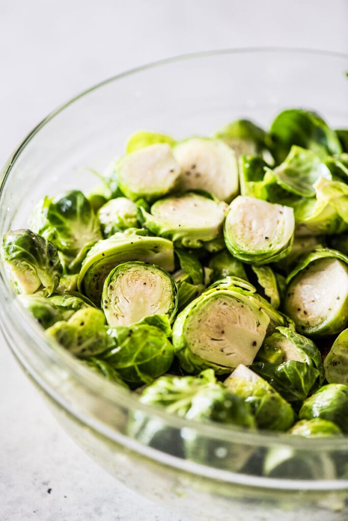 halved brussels sprouts in a blue bowl