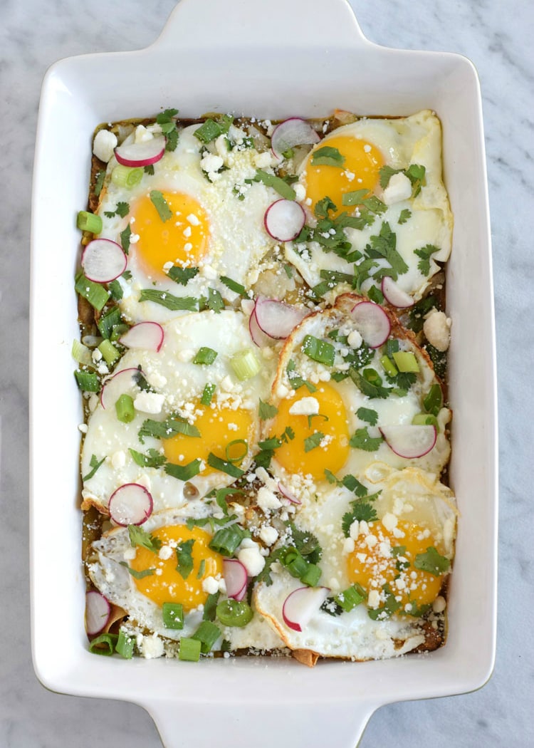 Made with baked corn tortillas covered in salsa verde and topped with sunny side-up eggs, fresh cilantro, radishes and green onions, this Mexican Salsa Verde Chilaquiles Casserole is the perfect breakfast and brunch dish. It's also gluten free and vegetarian, woo woo! // isabeleats.com