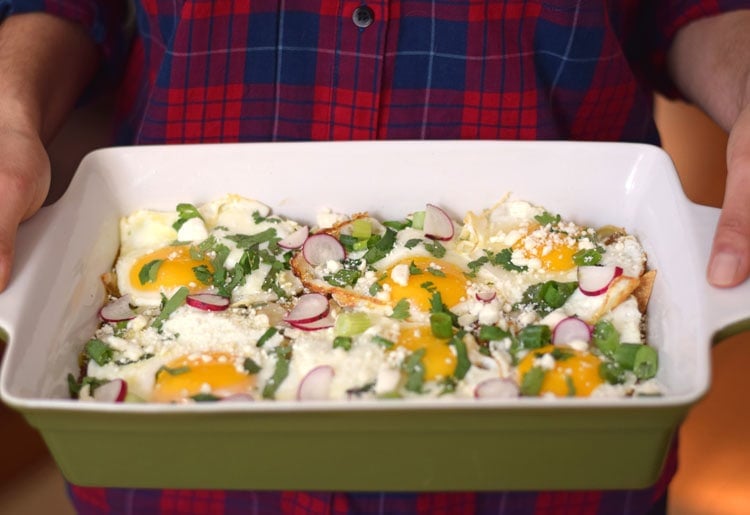 Made with baked corn tortillas covered in salsa verde and topped with sunny side-up eggs, fresh cilantro, radishes and green onions, this Mexican Salsa Verde Chilaquiles Casserole is the perfect breakfast and brunch dish. It's also gluten free and vegetarian, woo woo! // isabeleats.com