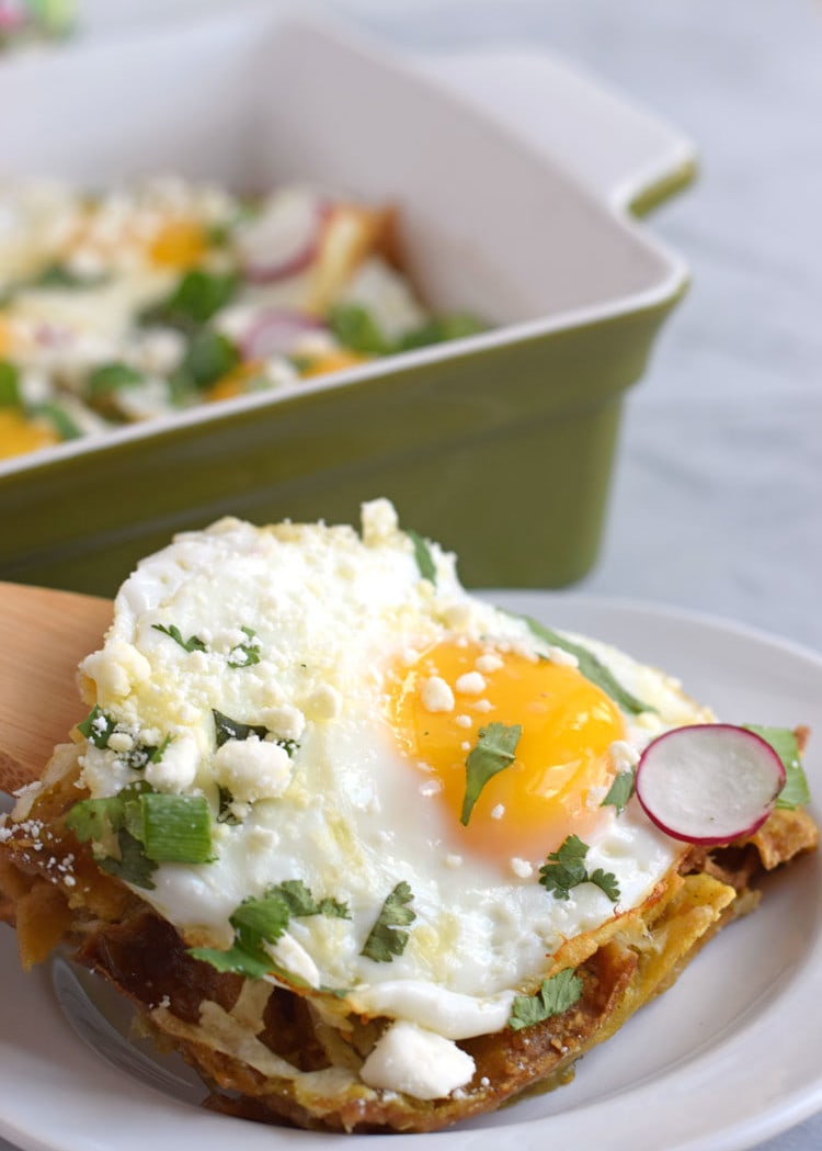 Made with baked corn tortillas covered in salsa verde and topped with sunny side-up eggs, fresh cilantro, radishes and green onions, this Mexican Salsa Verde Chilaquiles Casserole is the perfect breakfast and brunch dish. It's also gluten free and vegetarian, woo woo! // isabeleats.com