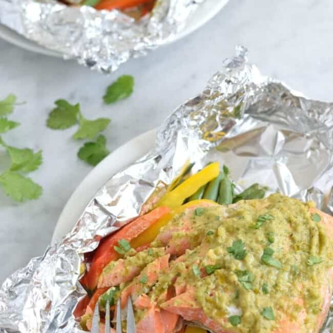 Topped with a green chile cilantro sauce, this Mexican Baked Salmon in Foil recipe is easy to make, takes 35 minutes from start to finish and is perfect for lunch and dinner. It's also super healthy and is gluten free, paleo, vegetarian and clean eating.