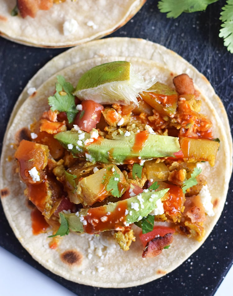 These Sriracha Potato & Egg Breakfast Tacos are the perfect brunch dish that everyone can enjoy. They're Mexican inspired with a little Thai flare. They're easily made vegetarian by omitting the bacon, are gluten free, paleo and pretty freakin' tasty! // isabeleats.com