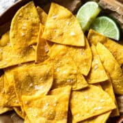 Baked tortilla chips in a bowl garnished with sea salt.