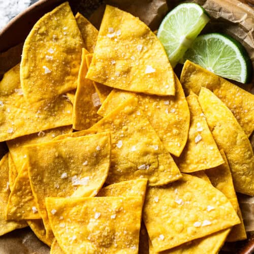 Baked tortilla chips in a bowl garnished with sea salt.