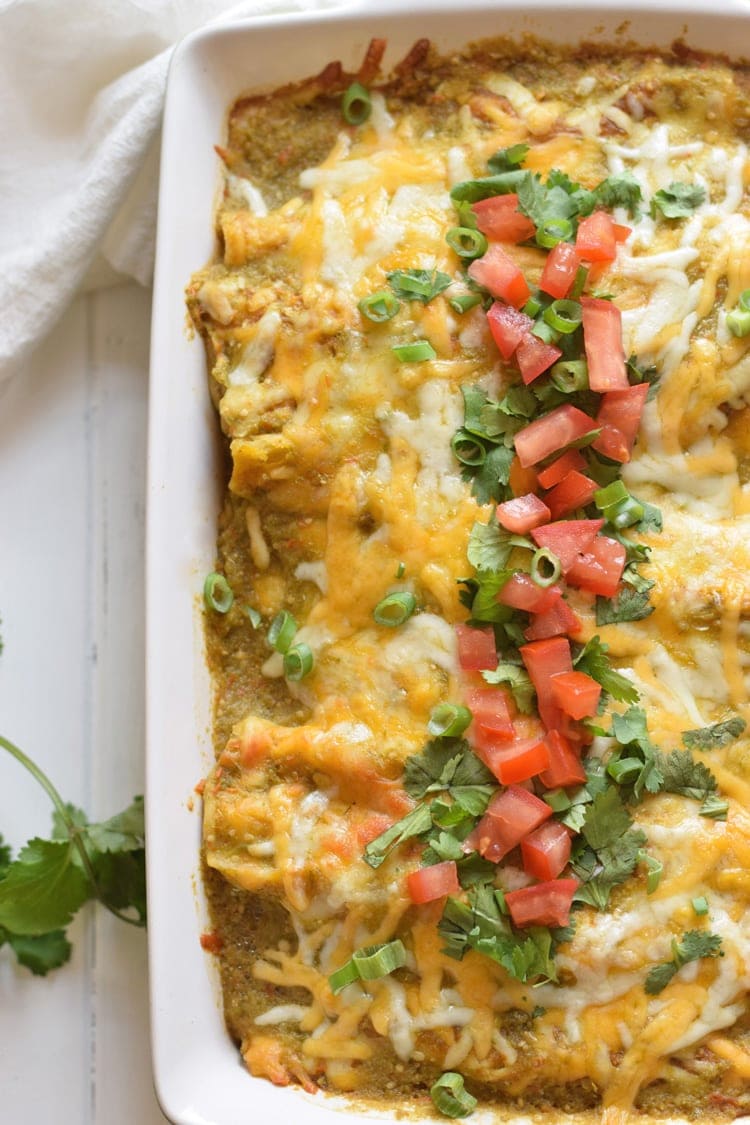 Enchiladas Verdes topped with chopped cilantro, tomatoes and melted cheese.