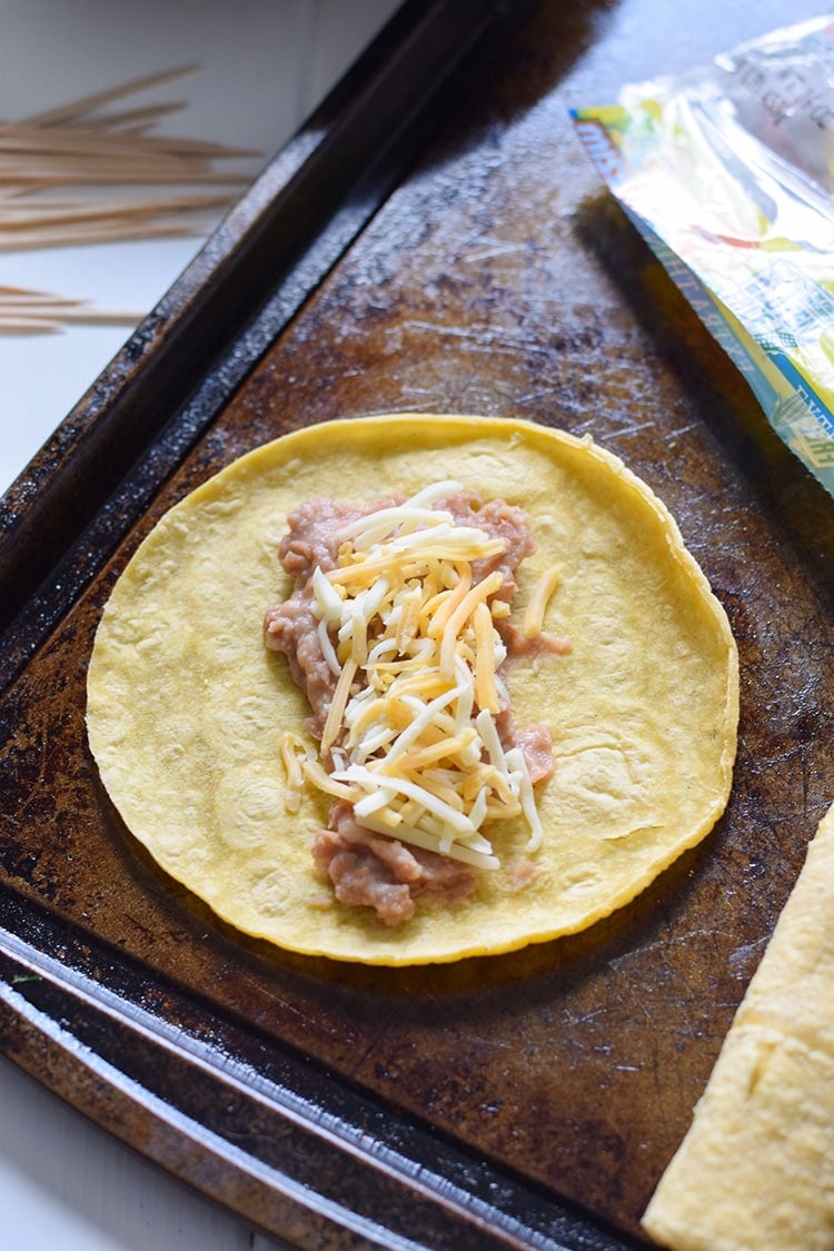 If you're looking for an easy, freezer-friendly meal, look no further than these Baked Chicken, Bean & Cheese Taquitos. Loaded with mashed pinto beans, shredded Mexican cheese and chili-spiced baked chicken, these taquitos are just like your favorite tacos, but even more fun to eat!