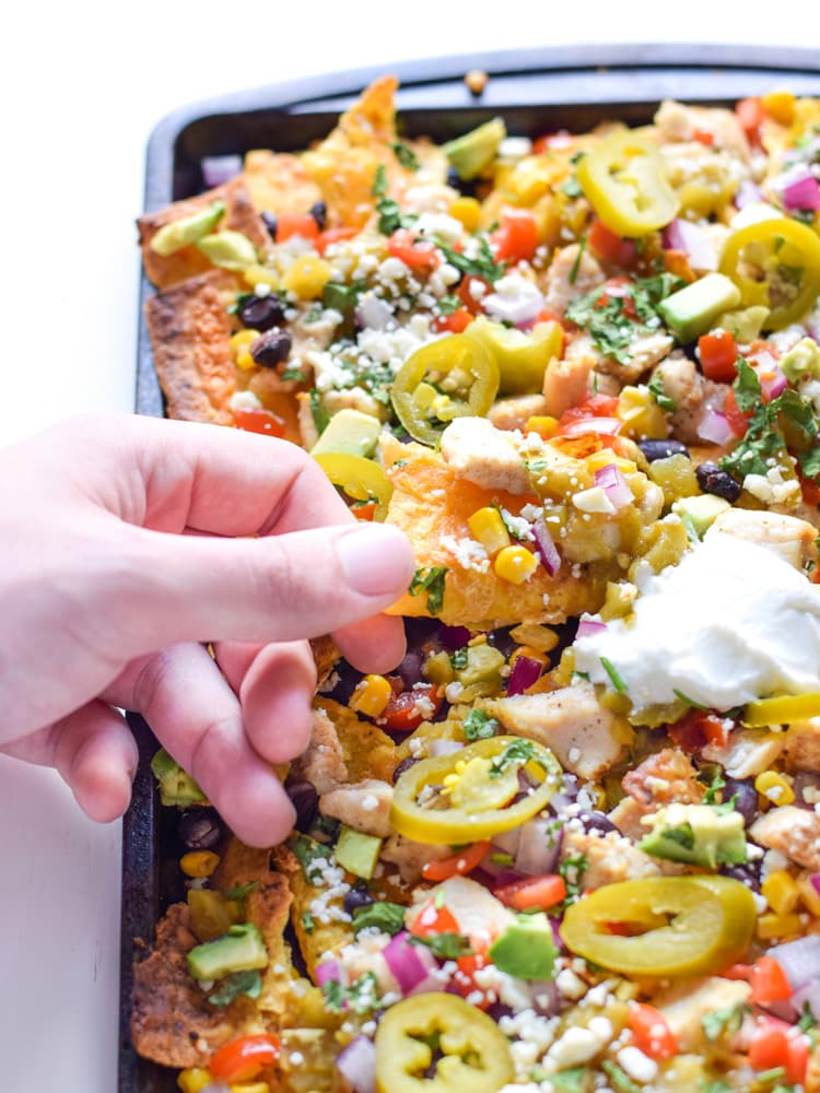 Now you can get your favorite restaurant appetizer right at home! These Easy Loaded Mexican Nachos are topped with all your favorite ingredients and take only 12 minutes to make. Perfect for parties or lazy weekend meals! Is gluten free and can easily be made vegetarian.