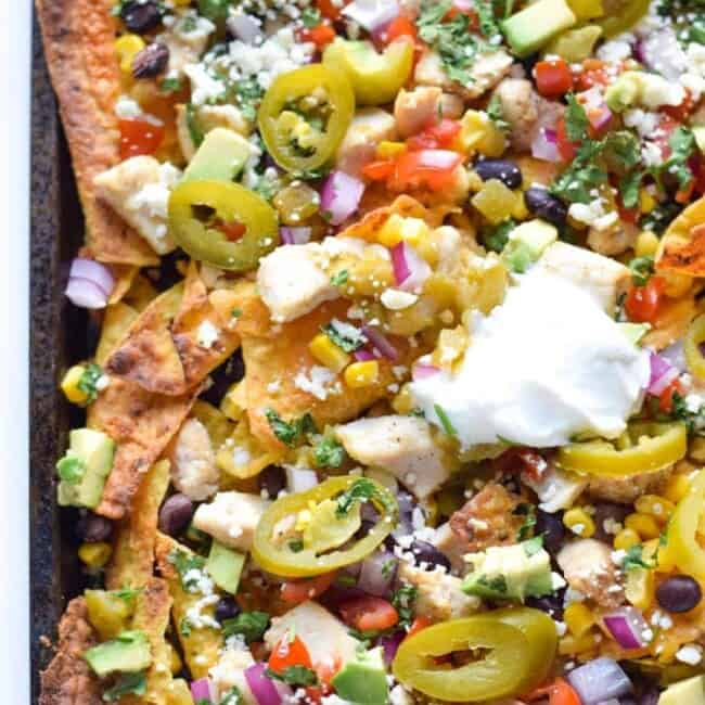 Now you can get your favorite restaurant appetizer right at home! These Easy Loaded Mexican Nachos are topped with all your favorite ingredients and take only 12 minutes to make. Perfect for parties or lazy weekend meals! Is gluten free and can easily be made vegetarian.