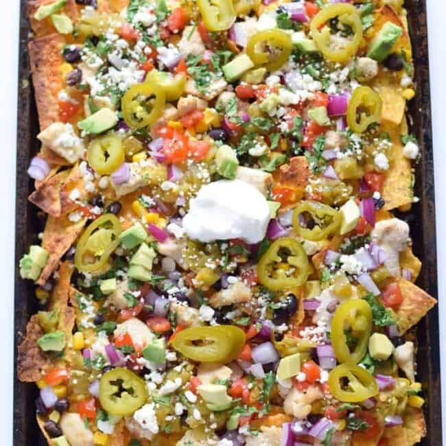 Now you can get your favorite restaurant appetizer right at home! These Easy Loaded Mexican Nachos are topped with all your favorite ingredients and take only 12 minutes to make. Perfect for parties or lazy weekend meals! Is gluten free and can easily be made vegetarian.