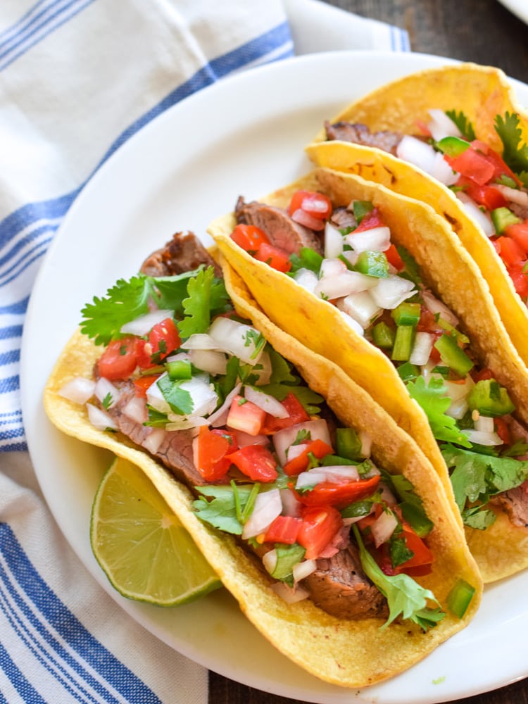Topped with fresh pico de gallo salsa for an added crunch, these easy-to-make Marinated Flank Steak Tacos are juicy, bright and super flavorful. Perfect for any weeknight meal! (gluten free, dairy free, paleo)