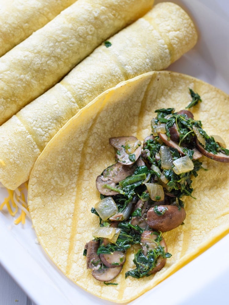 These Vegetarian Spinach Enchiladas are covered in a red enchilada sauce and stuffed with spinach, mushrooms and onions for a tasty Mexican dinner!