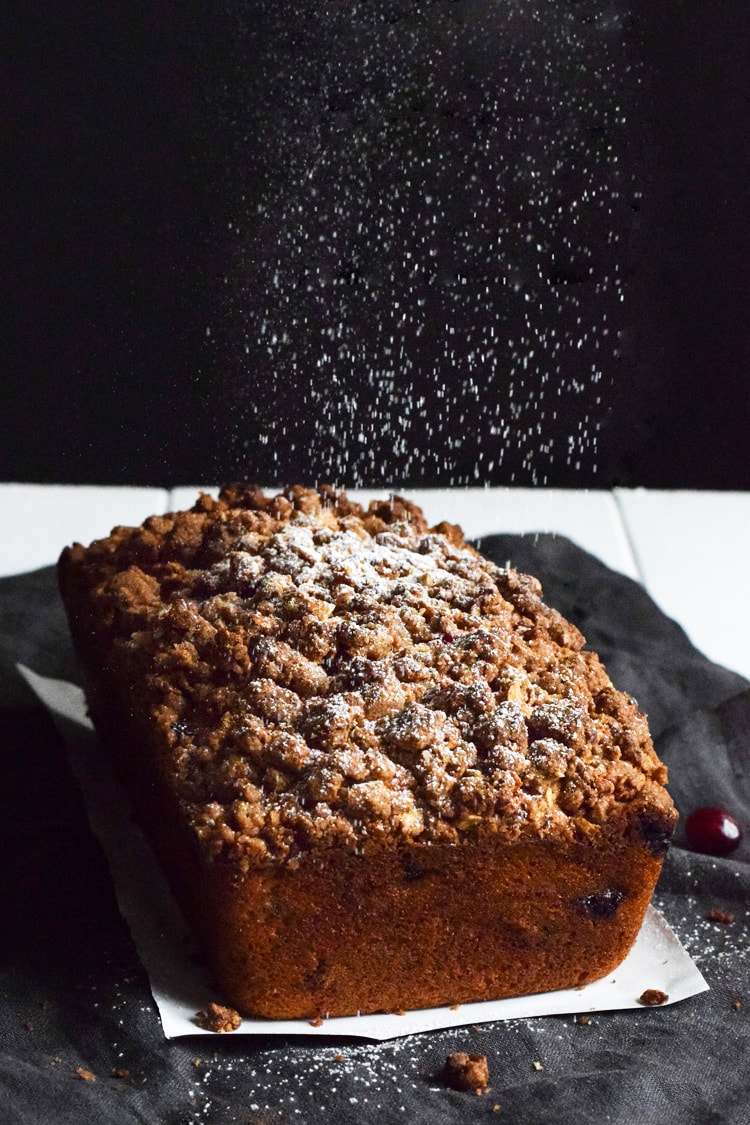 This Cranberry Banana Bread topped with a cinnamon granola crunch is super moist, fluffy and filled with cranberries. Perfect for the holidays!