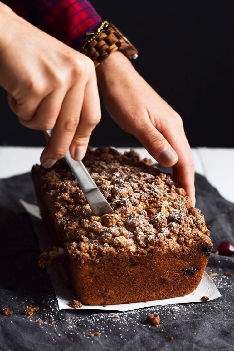 This Cinnamon Cranberry Crunch Banana Bread is super moist, fluffy, filled with cranberries and topped with a granola crumble. Perfect for the holidays!