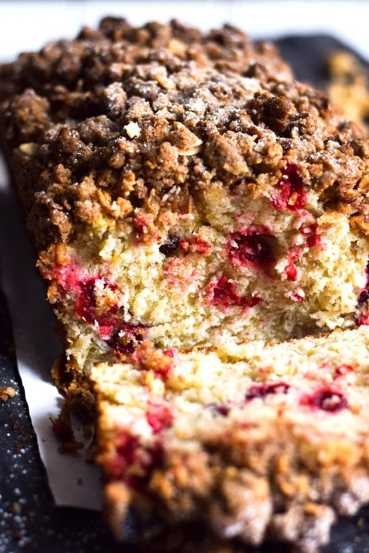 This Cinnamon Cranberry Crunch Banana Bread is super moist, fluffy, filled with cranberries and topped with a granola crumble. Perfect for the holidays!