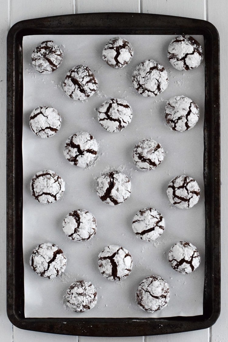 A sheet pan full of chocolate crinkle cookies.