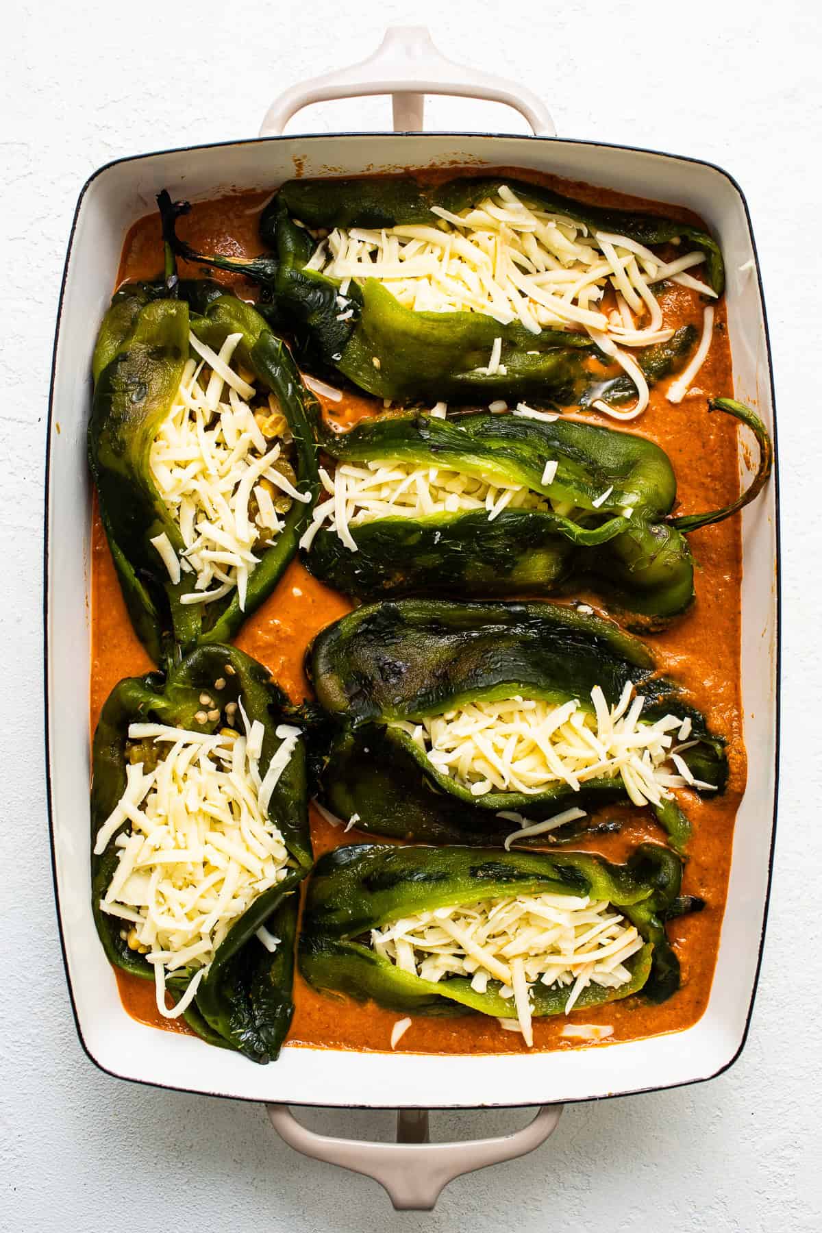 Baked chile relleno in a baking dish before being baked.