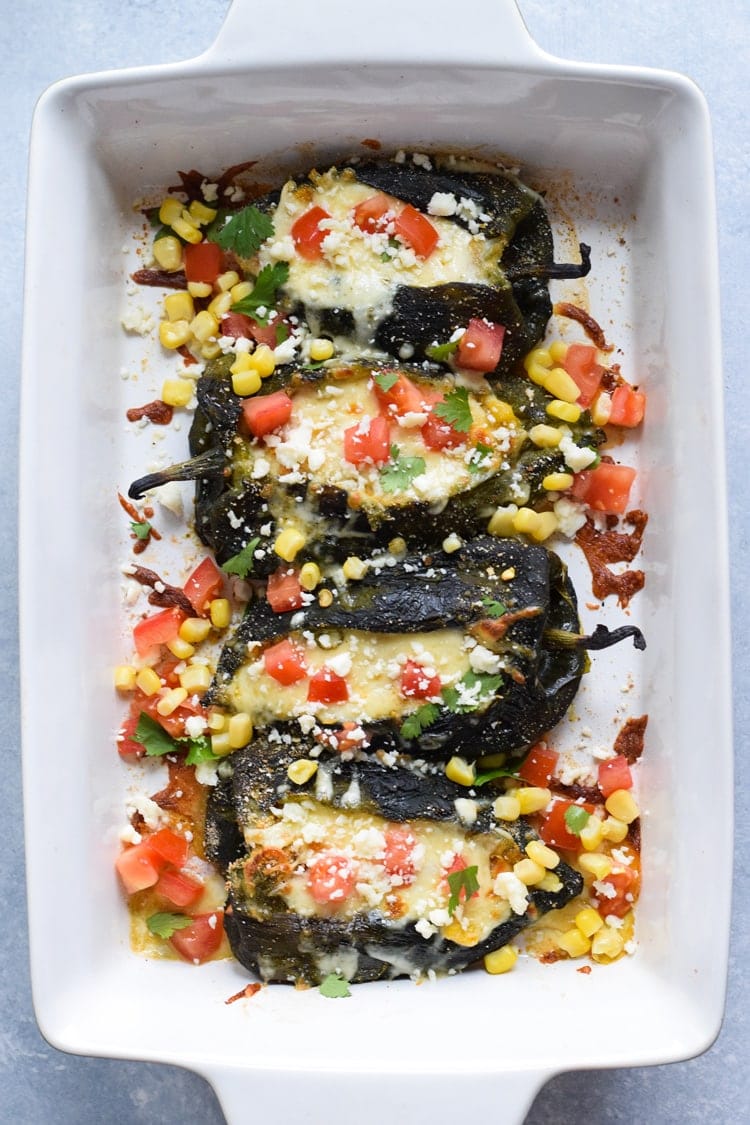 Baked chilis rellenos in a baking dish ready to be eaten.