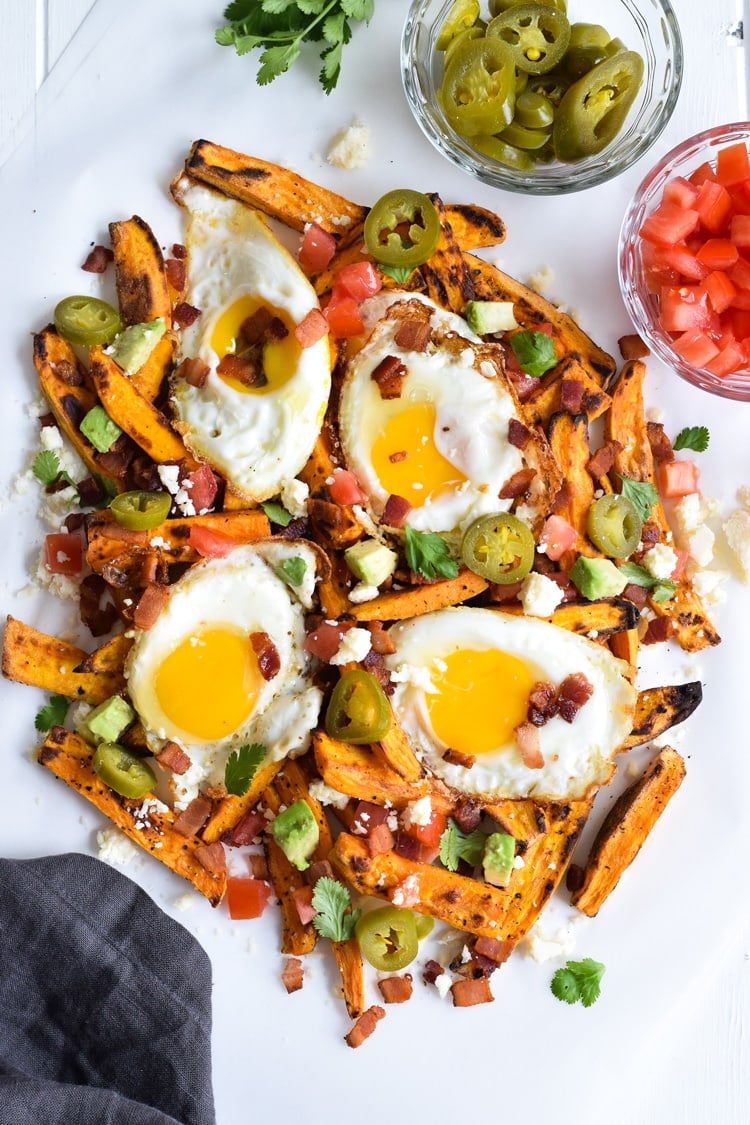 Baked Loaded Sweet Potato Breakfast Fries topped with sunny side up eggs, bacon, avocados and cotija cheese are sure to be your new favorite weekend breakfast.
