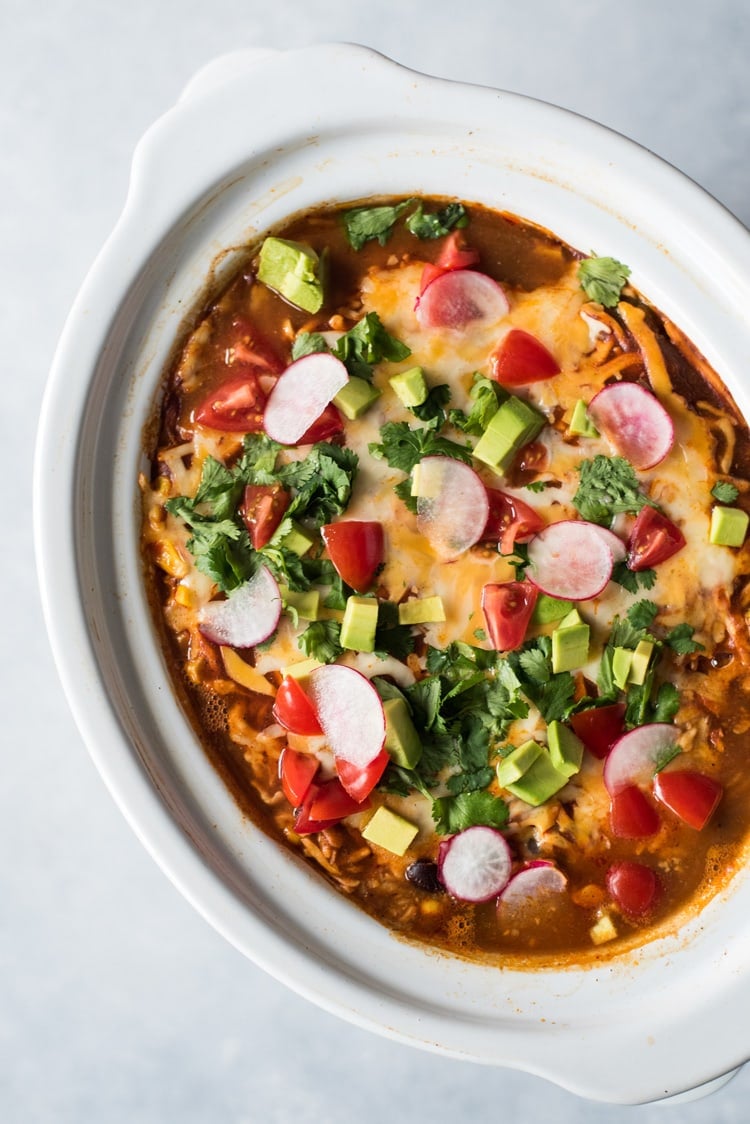 This Slow Cooker Mexican Lasagna is made with layers of black beans, corn tortillas and red enchilada sauce for a delicious gluten free weeknight meal!