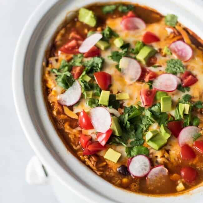 This Slow Cooker Mexican Lasagna is made with layers of black beans, corn tortillas and red enchilada sauce for a delicious gluten free weeknight meal!
