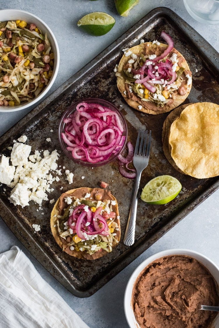 These Nopales Slaw Tostadas made with hominy and Mexican nopalitos (cactus leaves) are ready in only 35 minutes and are topped with homemade Easy Pickled Red Onions for a vegetarian and gluten free lunch.