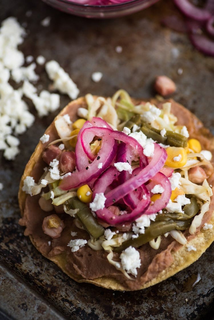 These Nopales Slaw Tostadas made with hominy and Mexican nopalitos (cactus leaves) are ready in only 35 minutes and are topped with homemade Easy Pickled Red Onions for a vegetarian and gluten free lunch.