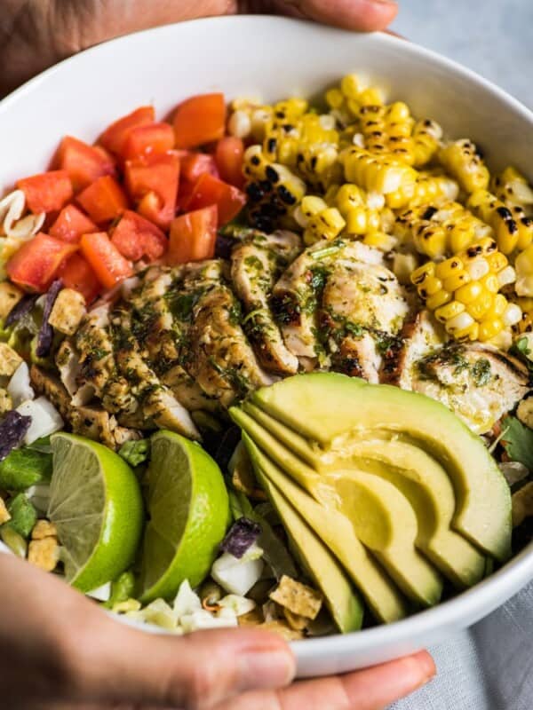 A bright, fresh Mexican Chimichurri Chicken Salad featuring grilled corn, summer tomatoes, marinated and grilled chimichurri chicken and creamy avocados. (gluten free)