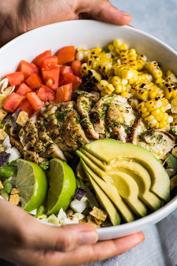 A bright, fresh Mexican Chimichurri Chicken Salad featuring grilled corn, summer tomatoes, marinated and grilled chimichurri chicken and creamy avocados. (gluten free)