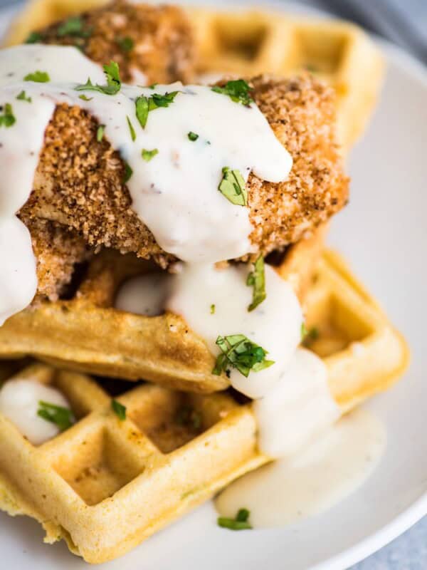 These savory Jalapeno Cornbread waffles are topped with crispy oven baked chicken tenders and white gravy for the ultimate brunch dish!