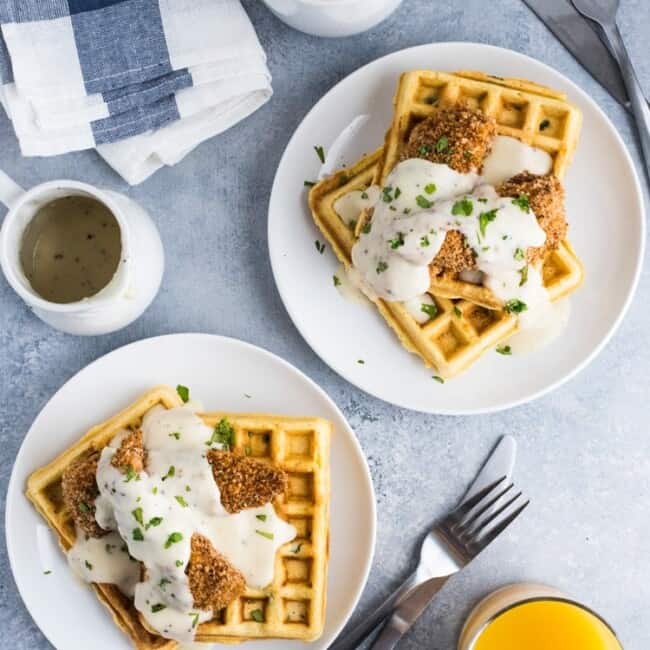 These savory Jalapeno Cornbread waffles are topped with crispy oven baked chicken tenders and white gravy for the ultimate brunch dish!