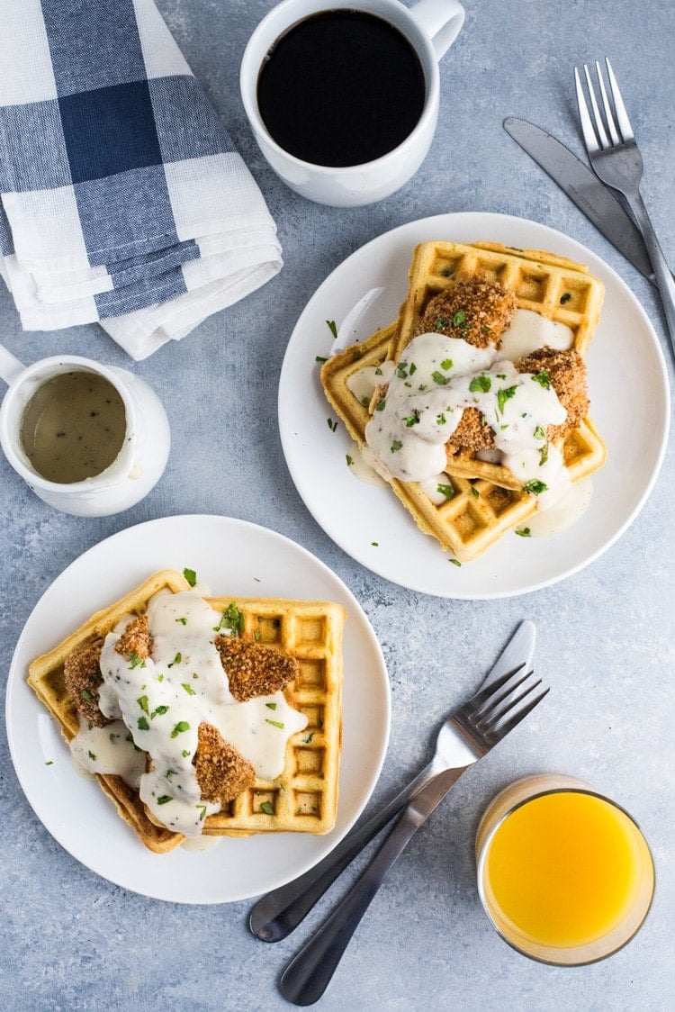 These savory Jalapeno Cornbread waffles are topped with crispy oven baked chicken tenders and white gravy for the ultimate brunch dish!