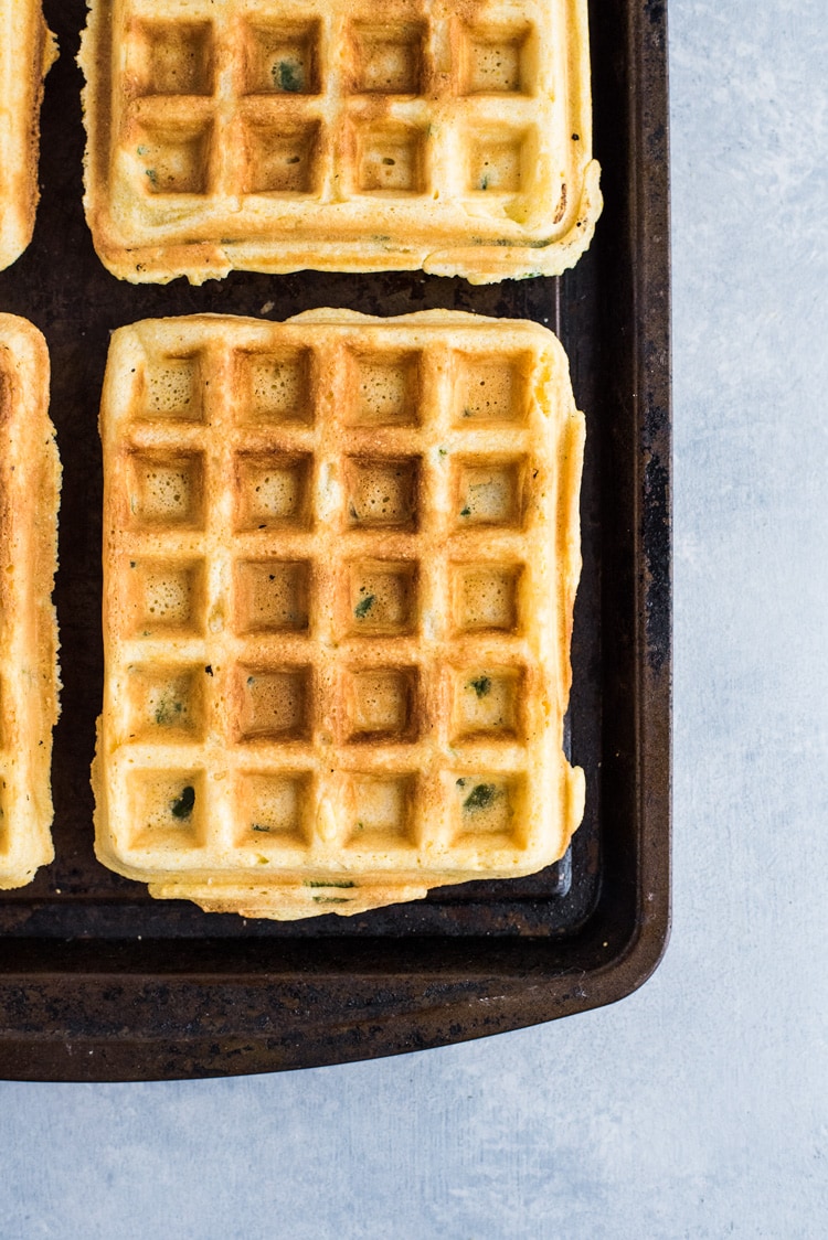 These savory Jalapeno Cornbread waffles are topped with crispy oven baked chicken tenders and white gravy for the ultimate brunch dish!