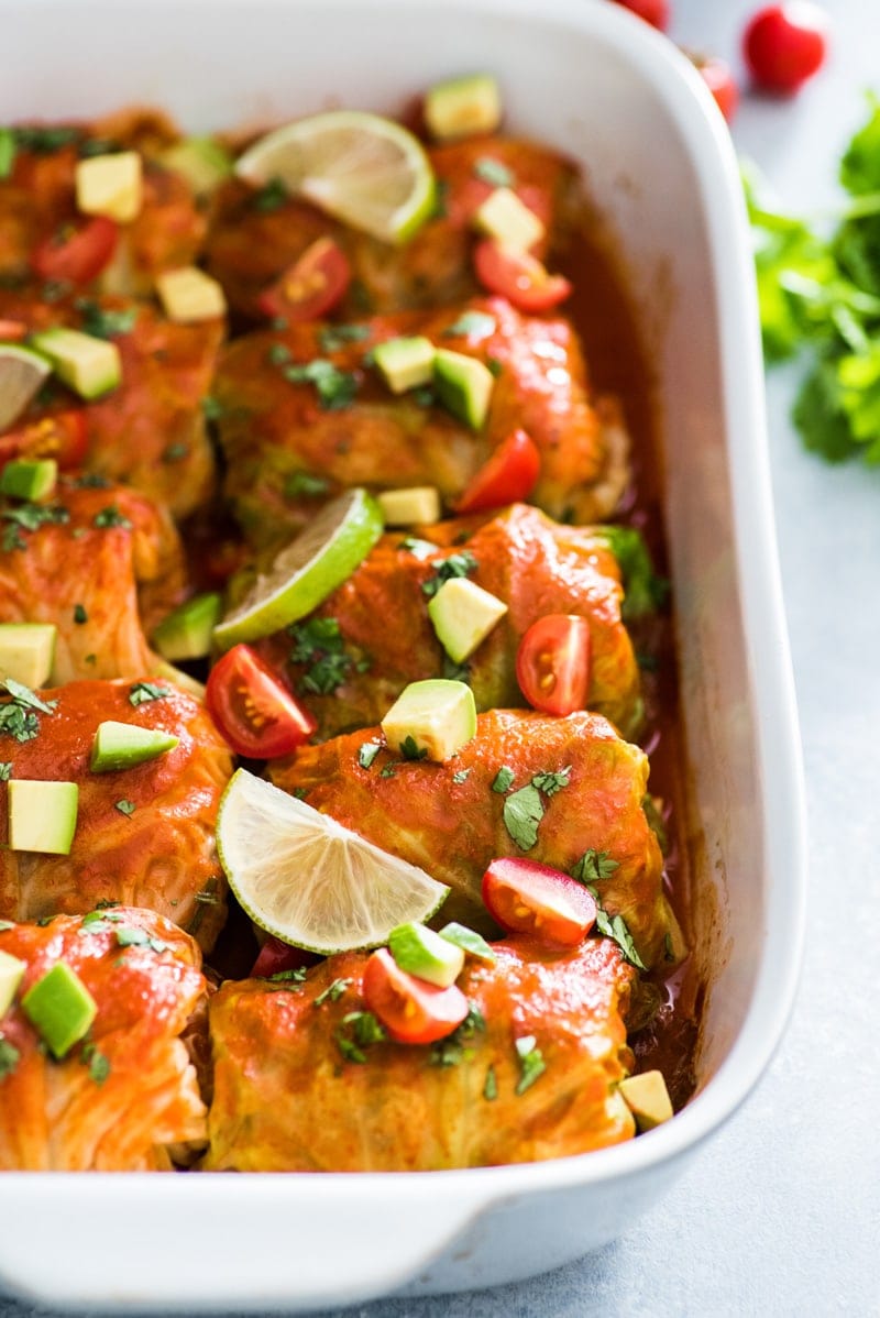 These Low Carb Enchilada Cabbage Rolls are made with cabbage leaves and stuffed with chicken, cheese and green chiles for a healthy weeknight meal!