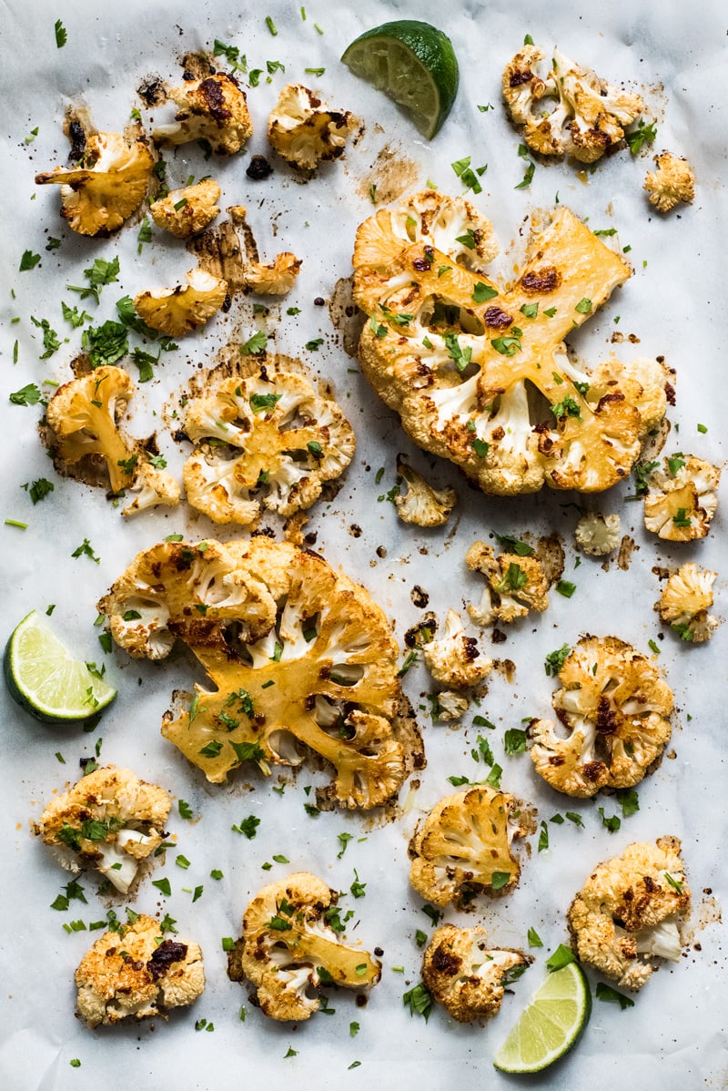 Chipotle Roasted Cauliflower on a white baking sheet topped with cilantro and lime juice.