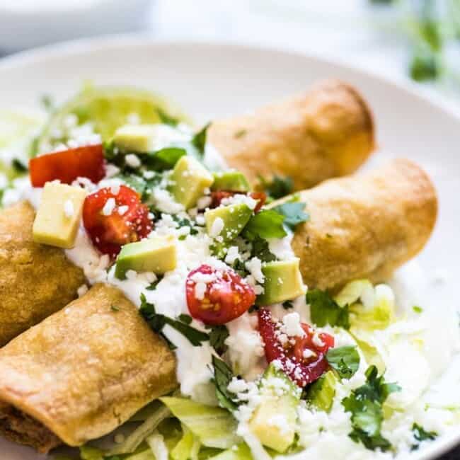 These Baked Chicken Taquitos are stuffed with seasoned shredded chicken, cream cheese, diced green chiles, black beans and corn. Perfect for any weeknight meal! (freezer friendly, gluten free)