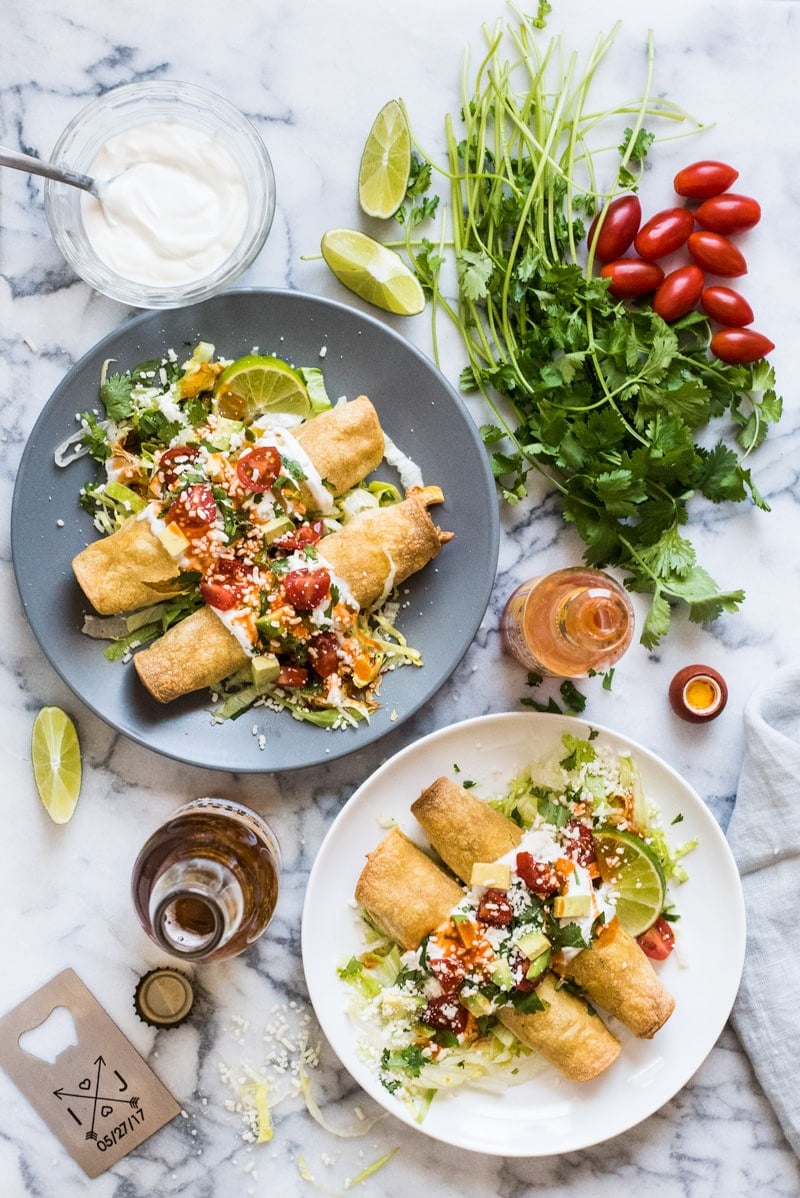 These baked Chicken Taquitos are stuffed with seasoned shredded chicken, cream cheese, diced green chiles, black beans and corn. Perfect for any weeknight meal! (freezer friendly, gluten free)