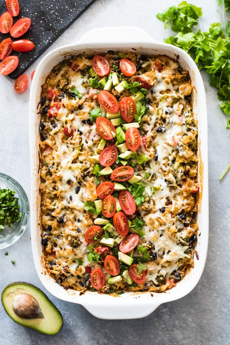 A Quinoa Enchilada Bake topped with tomatoes, cilantro and avocados.