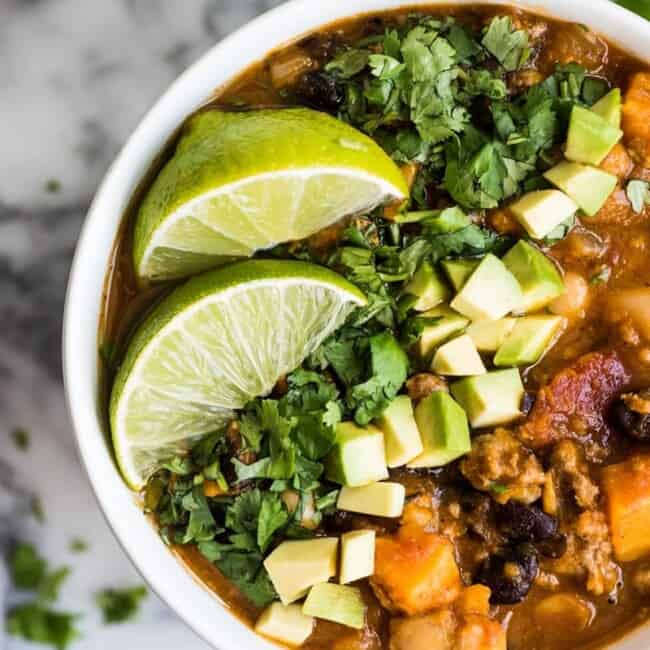 Turkey Pumpkin Chili in a white bowl with limes