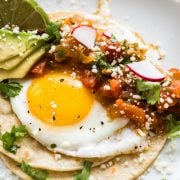 Huevos rancheros made from crispy corn tortillas, a fried egg, and salsa.