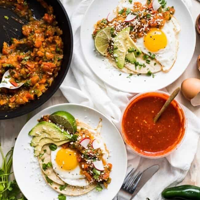 This Easy Huevos Rancheros recipe features crispy corn tortillas topped with fried eggs covered in a spicy tomato jalapeno salsa. (vegetarian, gluten free)