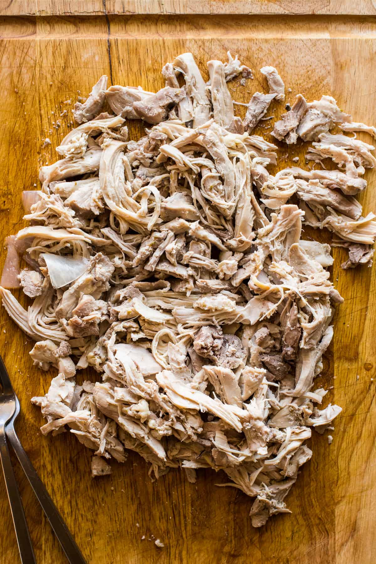 Shredded chicken on a cutting board.