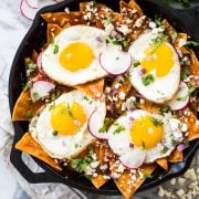 This Easy Red Chilaquiles recipe features baked corn tortillas, a red chile sauce and sunny side up eggs. Ready in 25 minutes! (gluten free, vegetarian)