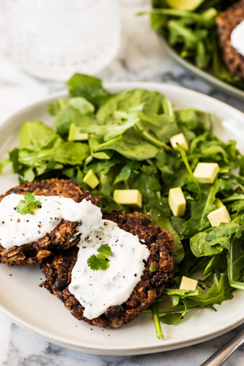 Black bean patties with a cilantro yogurt sauce on top.