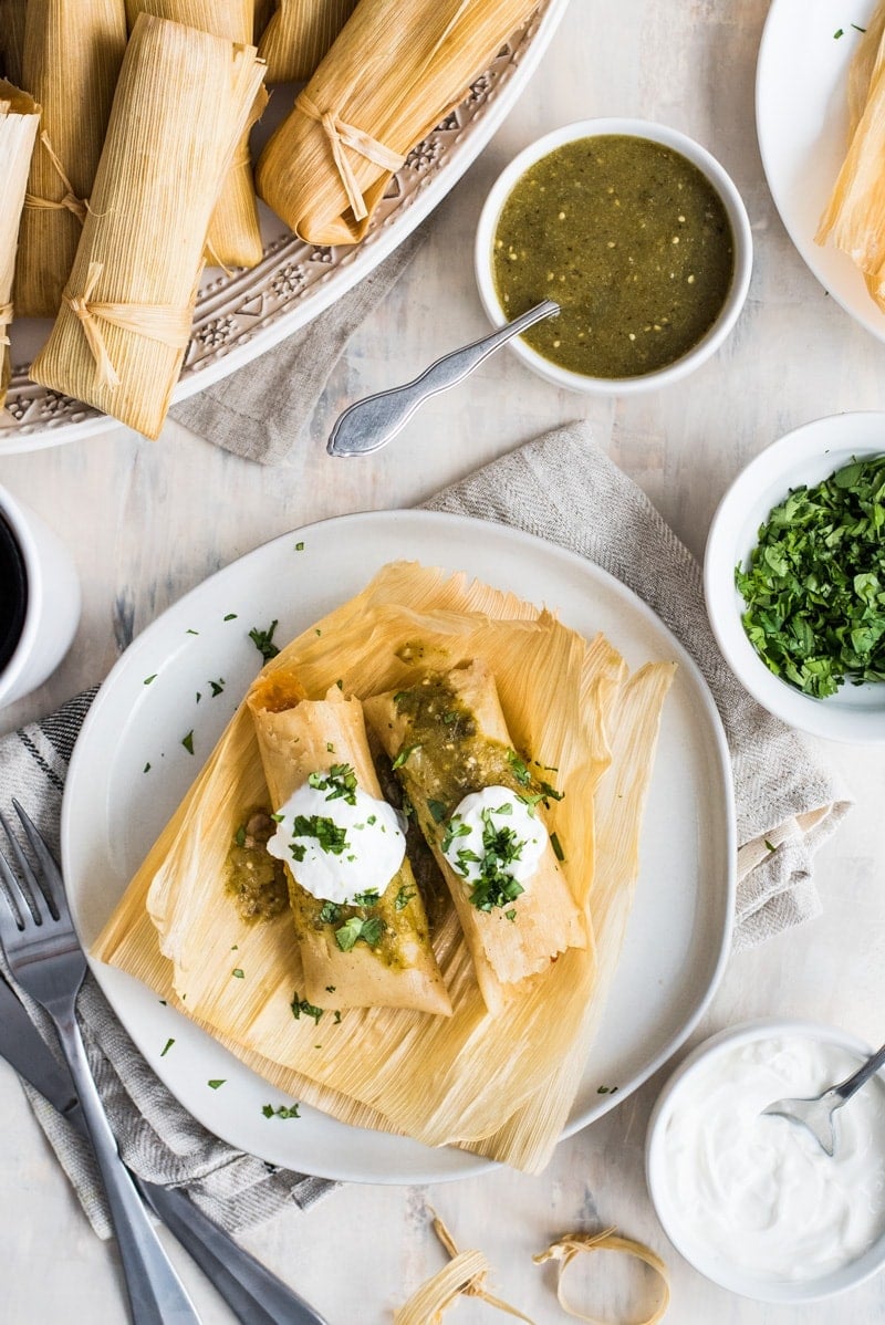 Tamales de Rajas (vegetarian tamales filled with roasted poblanos and cheese) on a table ready to eat.